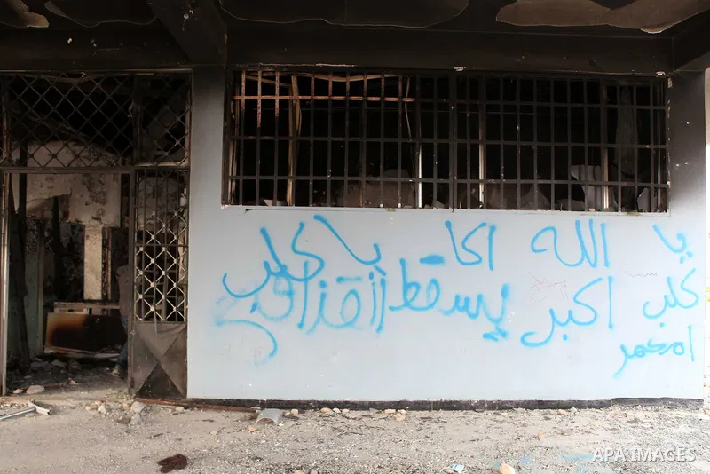 A man walks inside a burned police station in the eastern Libyan town of Derna on Feb. 23, 2011. Unrest shook Libya in recent days as government crackdowns on protesters have resulted in mass casualties, according to hum...