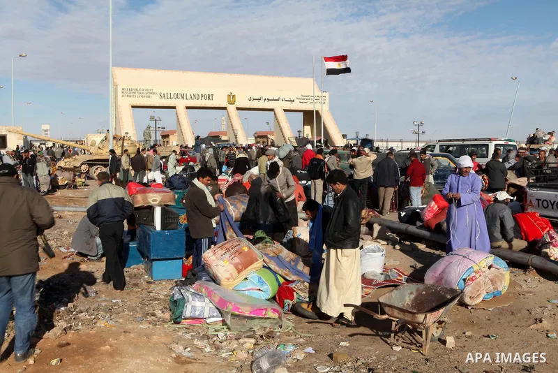 Egyptians, who have fled from Libya through the Salloum land port gate wait with their luggage,Wednesday, Feb. 23, 2011. An estimated 5,000 Egyptians have returned home from Libya by land, and about 10,000 more are waiti...