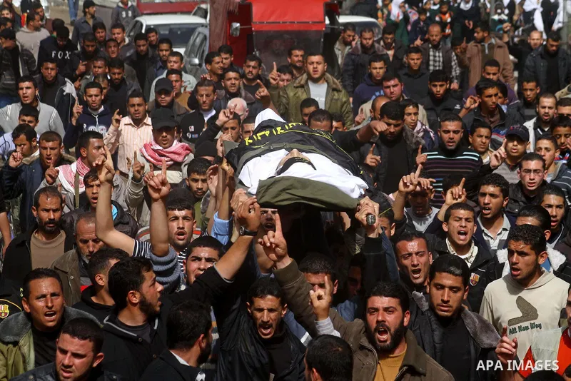 Palestinian mourners carry the body of Islamic Jihad militant Adel Jundia during his funeral in Gaza City on February 24, 2011, a day after he was killed by Israeli tank fire during clashes east of Gaza City. Ten other P...