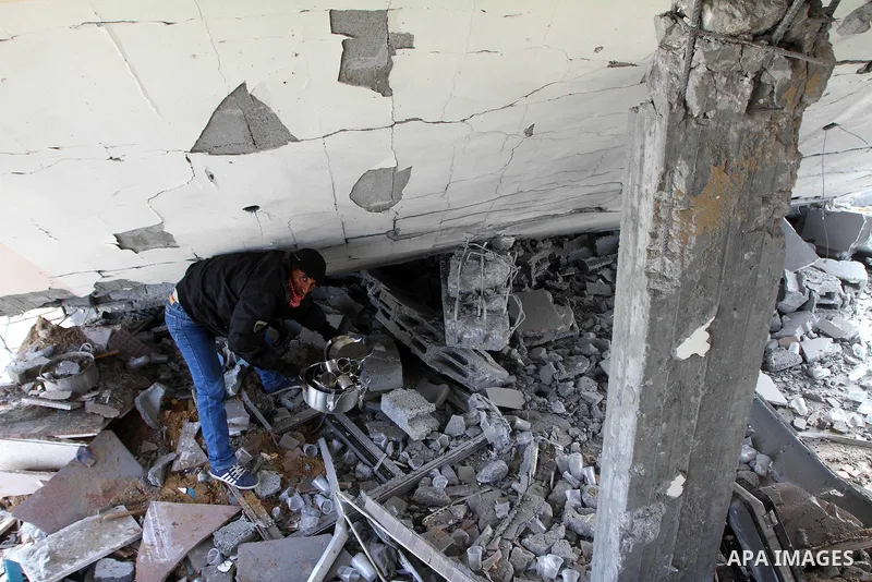 A Palestinian man surveys the damage the morning after an Israeli air strike in the Gaza Strip February 24, 2011. A rocket launched from the Gaza Strip landed in a residential street in the Israeli city of Beersheba Wedn...