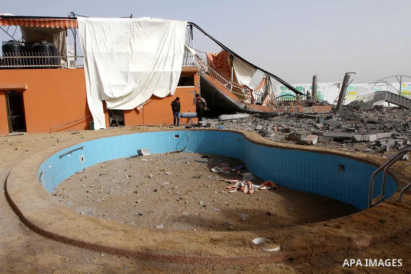 Palestinians survey the damage the morning after an Israeli air strike in the Gaza Strip February 24, 2011. A rocket launched from the Gaza Strip landed in a residential street in the Israeli city of Beersheba Wednesday...