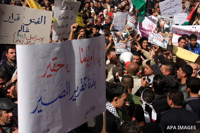 Palestinian protesters hold national flags and banners during a rally against the U.S. veto and calling for the national reconciliation in the West Bank city of Nablus, Thursday, Feb. 24, 2011. Photo by Wagdi Eshtayah