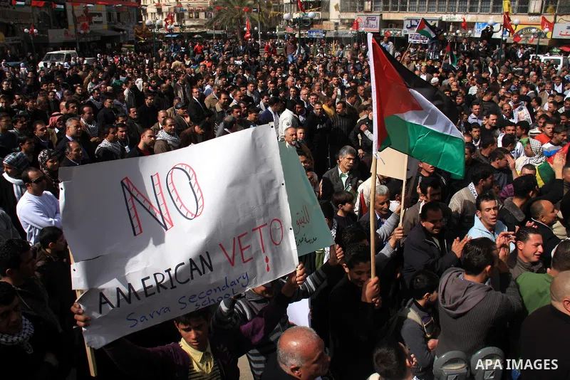 Palestinian protesters hold national flags and banners during a rally against the U.S. veto and calling for the national reconciliation in the West Bank city of Nablus, Thursday, Feb. 24, 2011. Photo by Wagdi Eshtayah