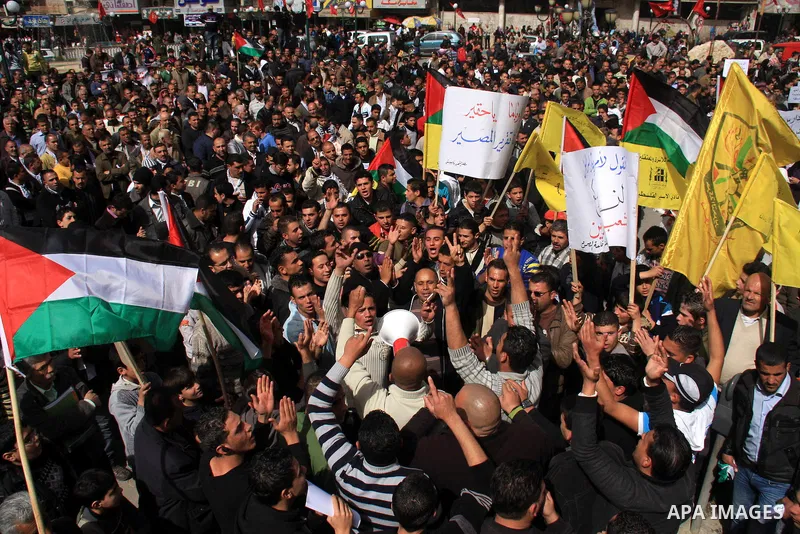 Palestinian protesters hold national flags and banners during a rally against the U.S. veto and calling for the national reconciliation in the West Bank city of Nablus, Thursday, Feb. 24, 2011. Photo by Wagdi Eshtayah