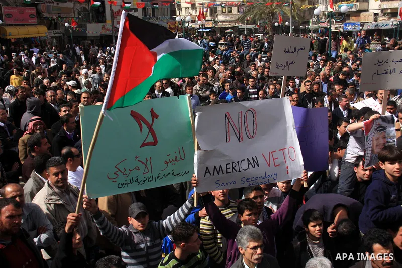 Palestinian protesters hold national flags and banners during a rally against the U.S. veto and calling for the national reconciliation in the West Bank city of Nablus, Thursday, Feb. 24, 2011. Photo by Wagdi Eshtayah