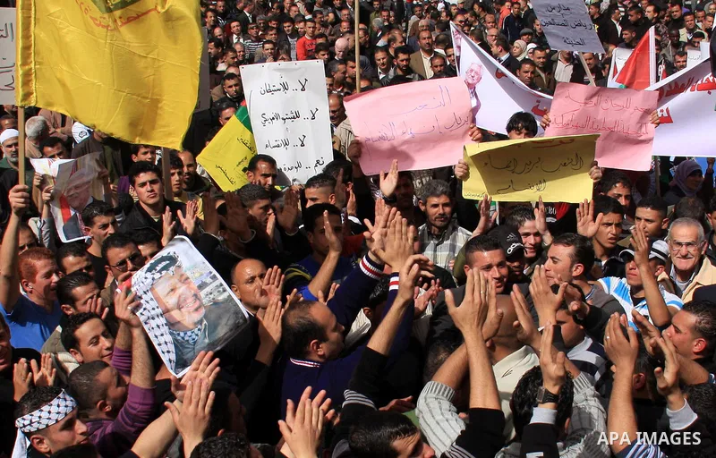 Palestinian protesters hold national flags and banners during a rally against the U.S. veto and calling for the national reconciliation in the West Bank city of Nablus, Thursday, Feb. 24, 2011. Photo by Wagdi Eshtayah