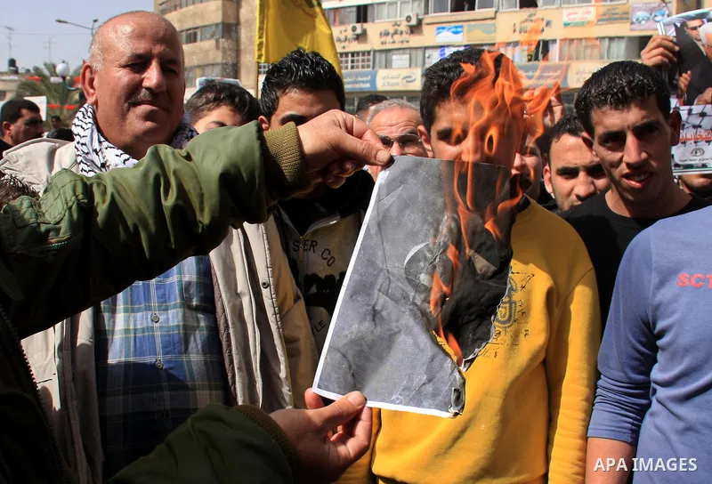 Palestinian protesters burn a placard of president Barack Obama, during a rally against the U.S. veto and calling for the national reconciliation in the West Bank city of Nablus, Thursday, Feb. 24, 2011. Photo by Wagdi E...