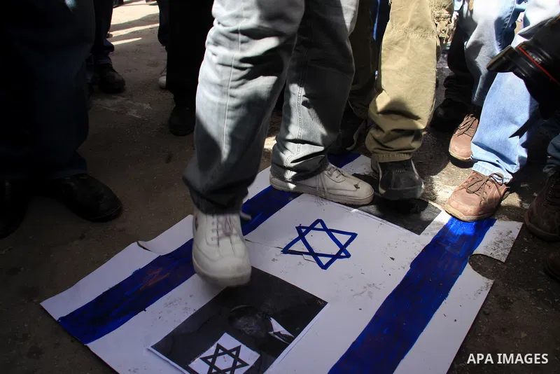 Palestinian protesters step on a poster of the Israel flag and president Barack Obama ,during a rally against the U.S. veto and calling for the national reconciliation in the West Bank city of Nablus, Thursday, Feb. 24,...