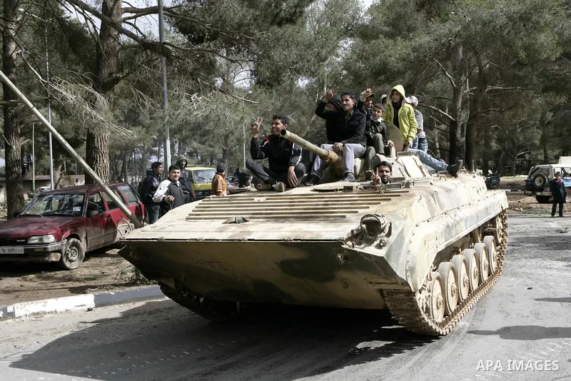 Anti-government protesters make victory signs as they stand on an army tank near a square where people are protesting in ALbedi city, Libya, February 24, 2011. Thousands of Libyans celebrated the liberation of the easter...