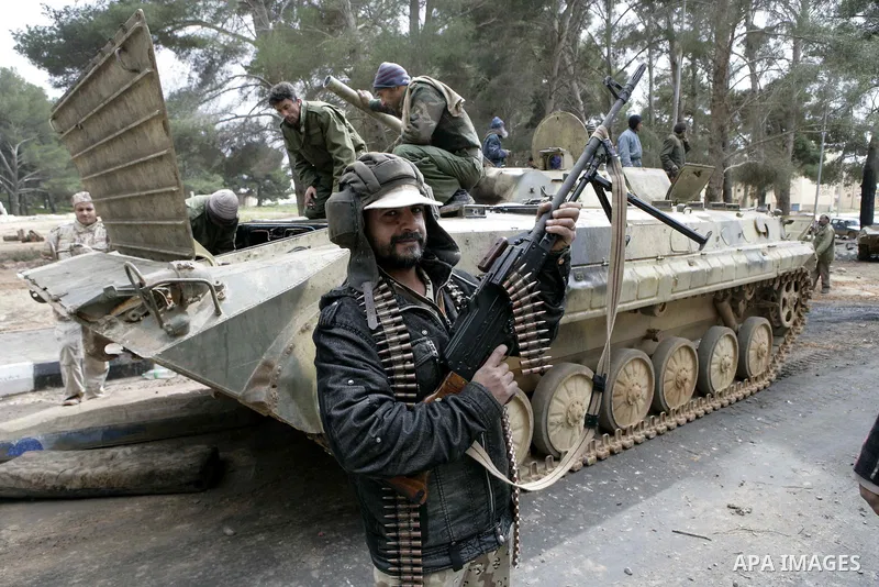 Anti-government protesters stand on an army tank near a square where people are protesting in ALbedi city, Libya, February 24, 2011. Thousands of Libyans celebrated the liberation of the eastern city of Benghazi from the...