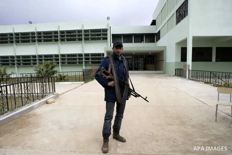 Anti-government protesters holds a gun near a square where people are protesting in ALbedi city, Libya, February 24, 2011. Thousands of Libyans celebrated the liberation of the eastern city of Benghazi from the rule of M...