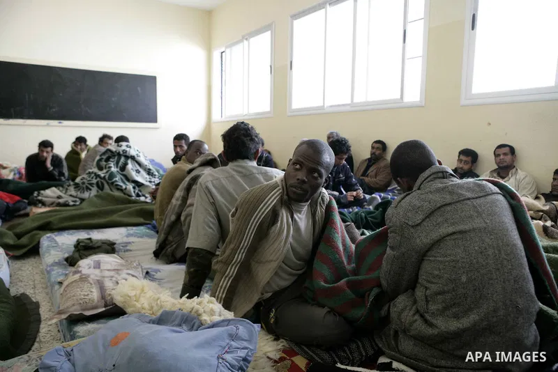 Suspected African mercenaries sit in a room in a school as they are held by anti-government protesters, in Albedia February 24, 2011. About a dozen people were being held in a school building who residents said were "mer...