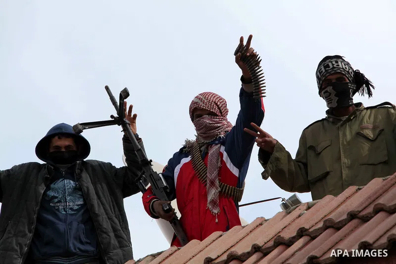 A Libyan gunman as he holds his automatic machine gun , in Albedia , Libya, on Thursday Feb. 24, 2011. A Libyan witness says a Libyan army unit has blasted a minaret of a mosque in a city west of Tripoli. The witness tel...