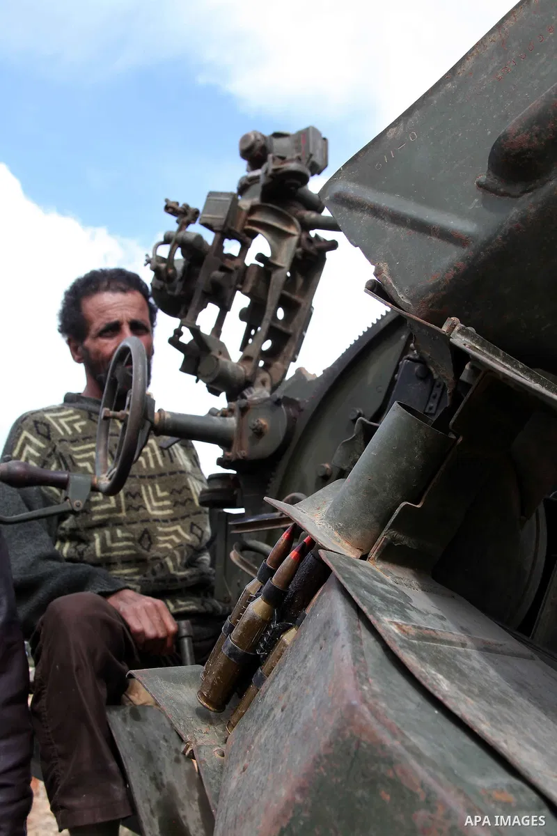 A Libyan gunman as he holds his automatic machine gun , in Albedia , Libya, on Thursday Feb. 24, 2011. A Libyan witness says a Libyan army unit has blasted a minaret of a mosque in a city west of Tripoli. The witness tel...