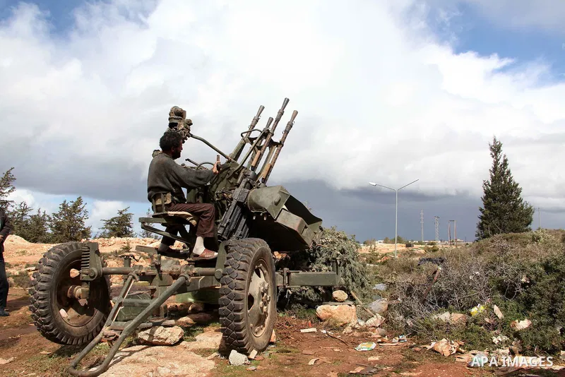 A Libyan gunman as he holds his automatic machine gun , in Albedia , Libya, on Thursday Feb. 24, 2011. A Libyan witness says a Libyan army unit has blasted a minaret of a mosque in a city west of Tripoli. The witness tel...