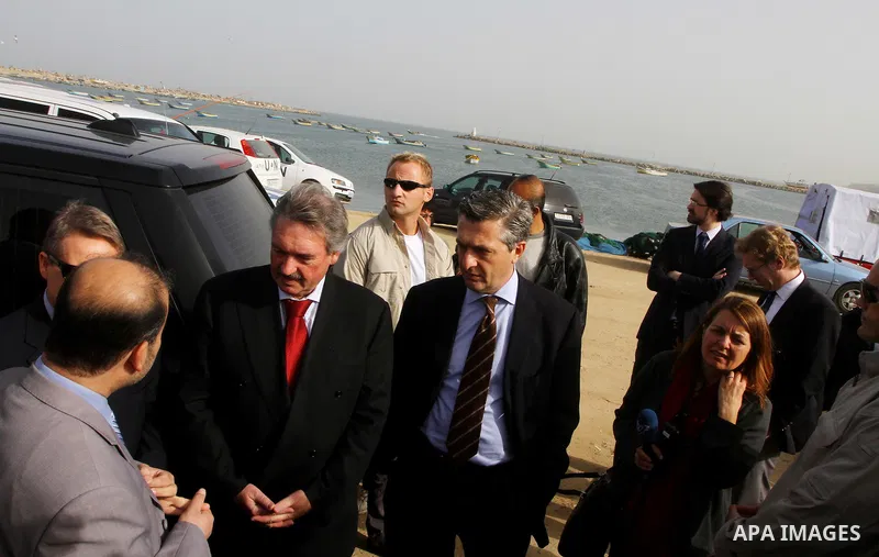 Luxembourg's Foreign Minister Jean Asselborn, centre, listens to explanation from UNRWA official upon his arrival to the Gaza fishermen port in Gaza City, Friday, Feb. 25, 2011. Asselborn is on an official visit to Gaza....
