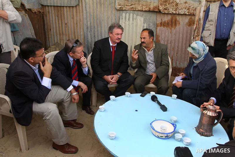 Luxembourg's Foreign Minister Jean Asselborn, centre, listens to explanation from UNRWA official upon his arrival to the Gaza fishermen port in Gaza City, Friday, Feb. 25, 2011. Asselborn is on an official visit to Gaza....