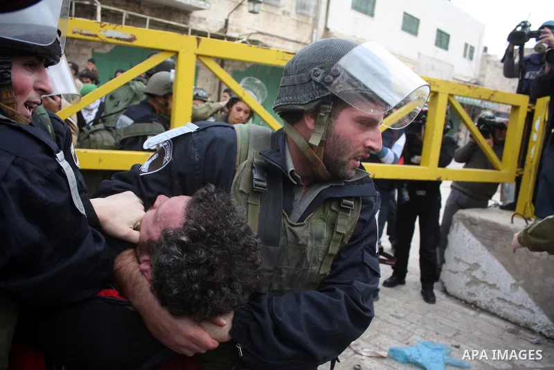 Israeli police officers try to push back Palestinian, Israeli and foreign activists during a protest against the continued closure of Shuhada street to Palestinians, in the West Bank city of Hebron 25 February 2011. The...