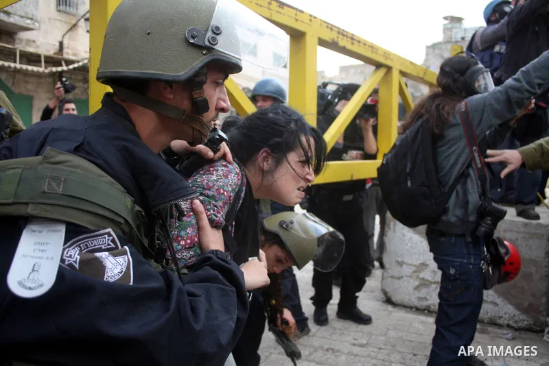Israeli police officers try to push back Palestinian, Israeli and foreign activists during a protest against the continued closure of Shuhada street to Palestinians, in the West Bank city of Hebron 25 February 2011. The...