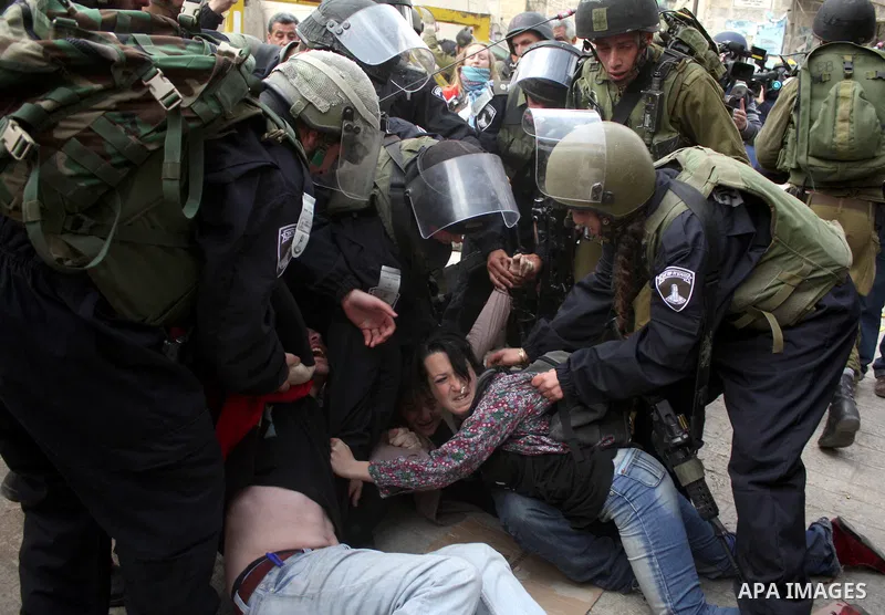 Israeli police officers try to push back Palestinian, Israeli and foreign activists during a protest against the continued closure of Shuhada street to Palestinians, in the West Bank city of Hebron 25 February 2011. The...