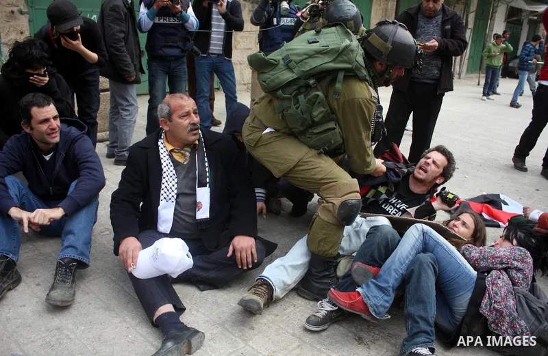 Israeli police officers try to push back Palestinian, Israeli and foreign activists during a protest against the continued closure of Shuhada street to Palestinians, in the West Bank city of Hebron 25 February 2011. The...