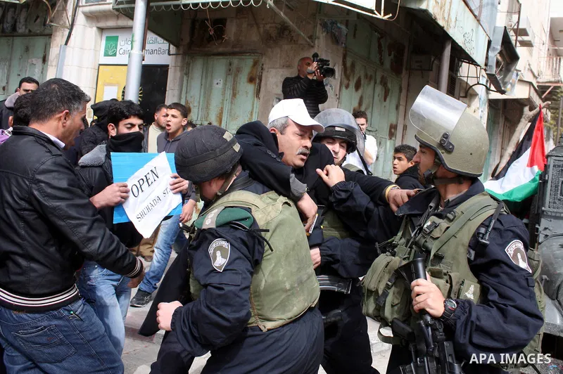 Israeli police officers try to push back Palestinian, Israeli and foreign activists during a protest against the continued closure of Shuhada street to Palestinians, in the West Bank city of Hebron 25 February 2011. The...