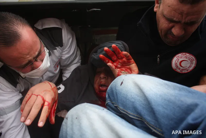 Palestinian medics help wounded Palestinian youths during a protest against the continued closure of Shuhada street to Palestinians, in the West Bank city of Hebron 25 February 2011. The activists gathered on Friday call...