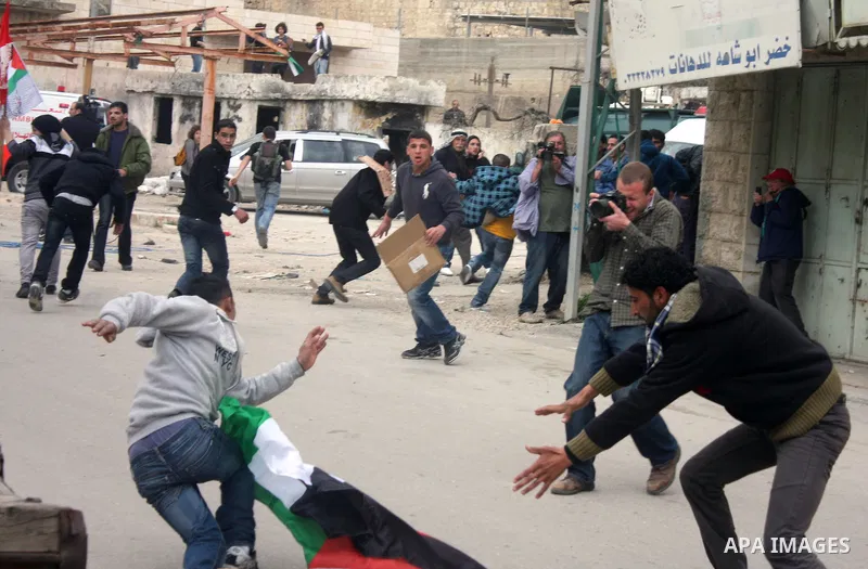 Palestinian, Israeli and foreign activists take part in a protest against the continued closure of Shuhada street to Palestinians, in the West Bank city of Hebron 25 February 2011. The activists gathered on Friday callin...