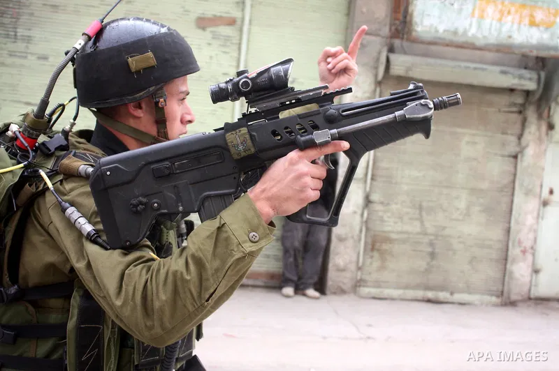 Israeli police officer fires tear gas canisters towards Palestinian, Israeli and foreign activists during a protest against the continued closure of Shuhada street to Palestinians, in the West Bank city of Hebron 25 Febr...