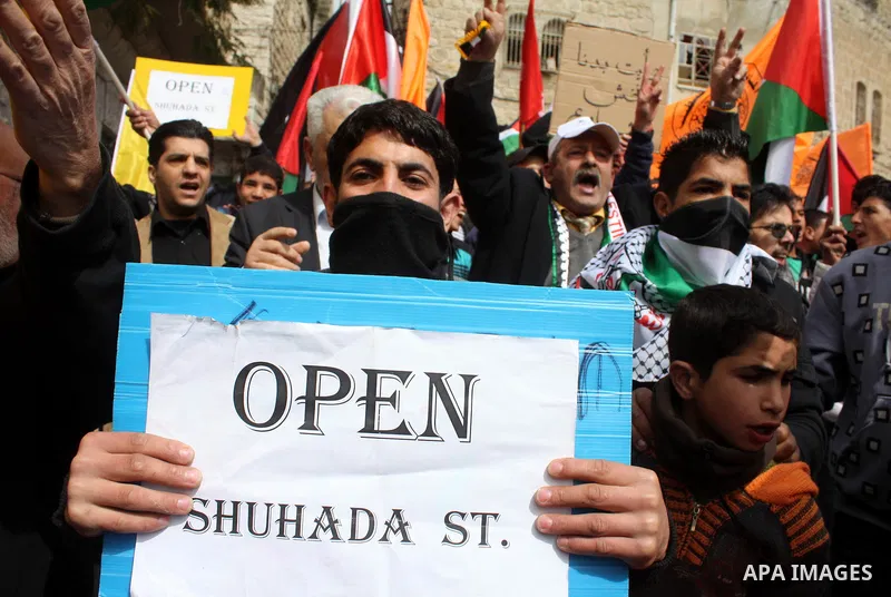Palestinian, Israeli and foreign activists take part in a protest against the continued closure of Shuhada street to Palestinians, in the West Bank city of Hebron 25 February 2011. The activists gathered on Friday callin...