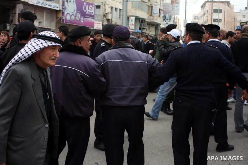 Palestinian riot-police take positions to prevent clashes between Palestinian protesters and Israeli security forces, not pictured, during a demonstration against the closure of Shuhada street to Palestinians, in the Wes...
