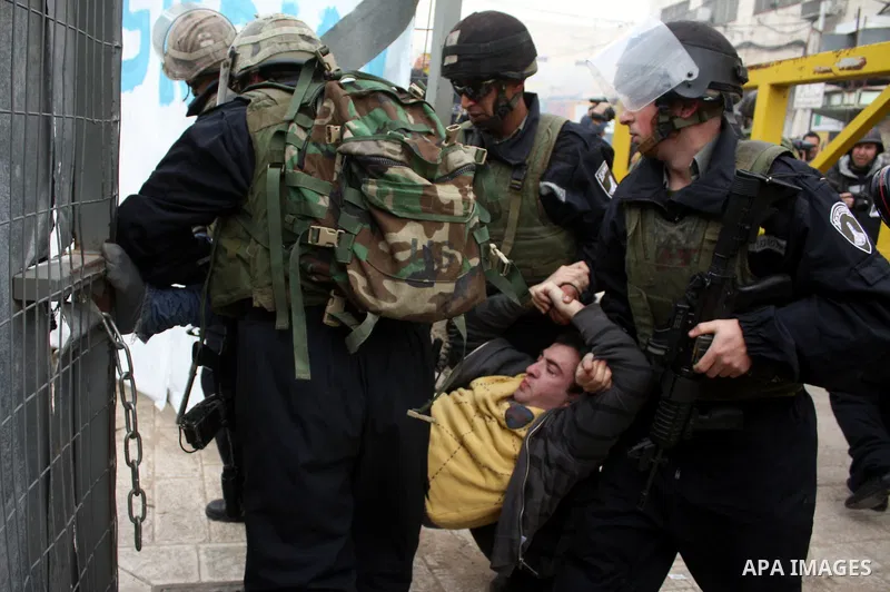 Israeli police officers detain a Palestinian youth during a protest against the continued closure of Shuhada street to Palestinians, in the West Bank city of Hebron 25 February 2011. The activists gathered on Friday call...