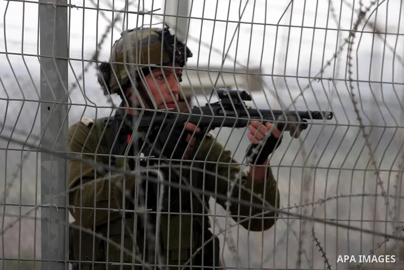 Israeli soldiers take position during a Palestinian protest against the controversial Israeli barrier in the West Bank village of Bilin near Ramallah, Feb. 25, 2011. Photo by Issam Rimawi