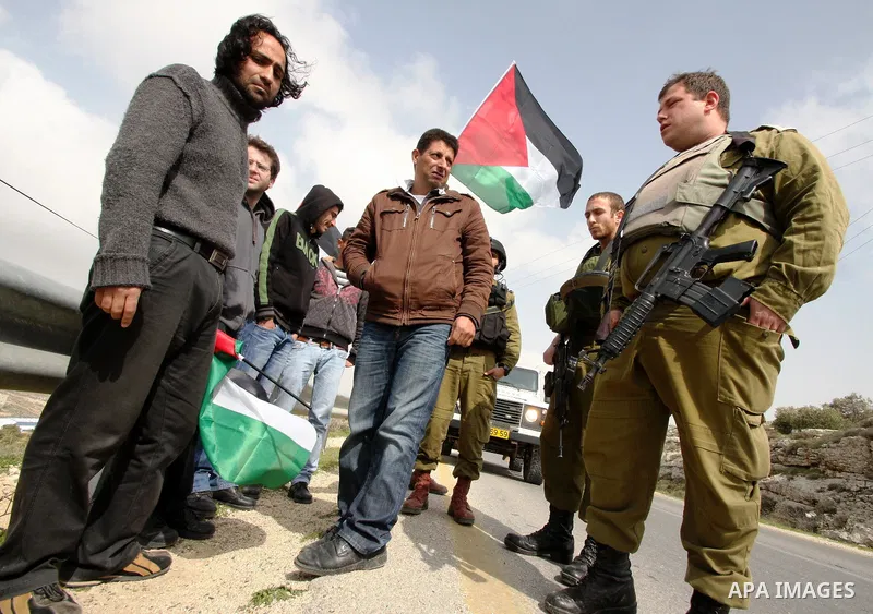 Protesters argue with an Israeli soldier during a demonstration against Israel's controversial separation barrier in the West Bank village of Maasarah, near the biblical town of Bethlehem on 25 February 2011.Israel says...