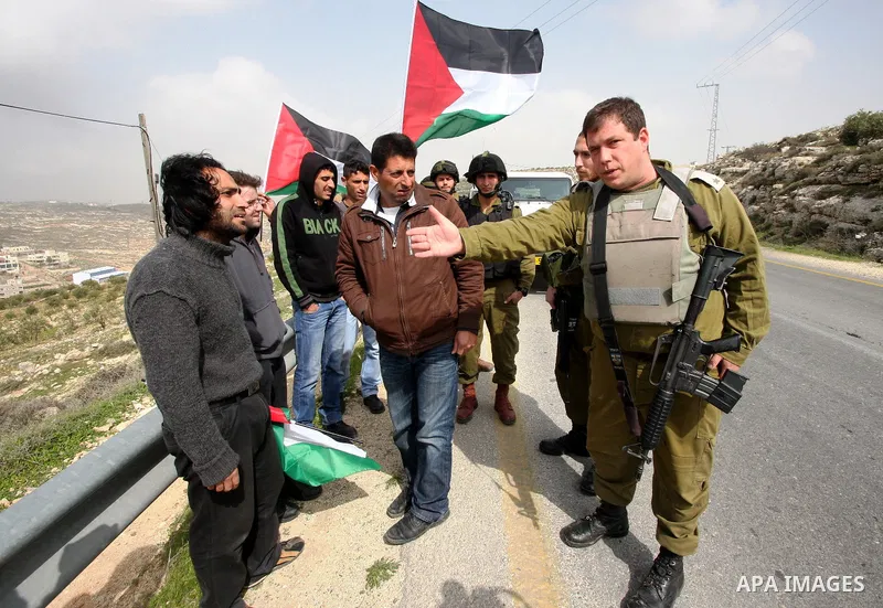 Protesters argue with an Israeli soldier during a demonstration against Israel's controversial separation barrier in the West Bank village of Maasarah, near the biblical town of Bethlehem on 25 February 2011.Israel says...