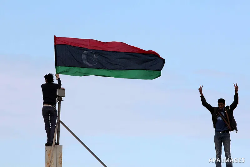 Libyan protester holds the national flag during a rally against Libyan leader Moammar Gadhafi at the Court Square in Derna, Libya, on Feb. 25, 2011. Photo by Karam Nasser