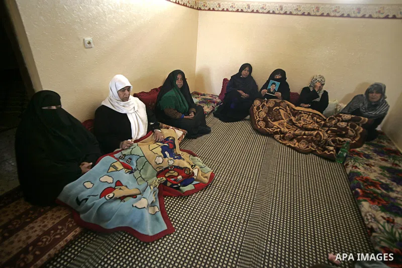 Palestinian relatives of Hassan Abu Mustafa mourn in his home in Khan Younis in the southern Gaza Strip on February 26, 2011. Pro-Gaddafi gunmen shot and killed Palestinian student Hasan Abu Mustafa outside his home in L...
