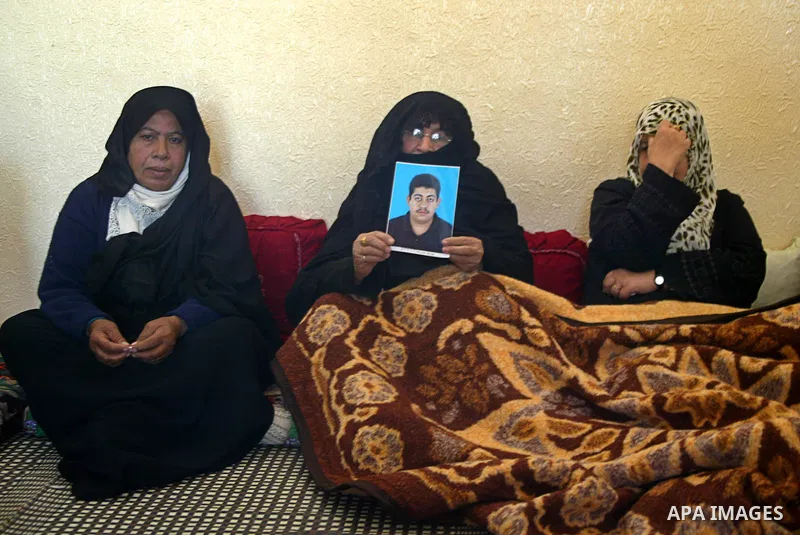 A Palestinian relative of Hasan Abu Mustafa holds his picture in his home in Khan Younis in the southern Gaza Strip on February 26, 2011. Pro-Gaddafi gunmen shot and killed Palestinian student Hasan Abu Mustafa outside h...