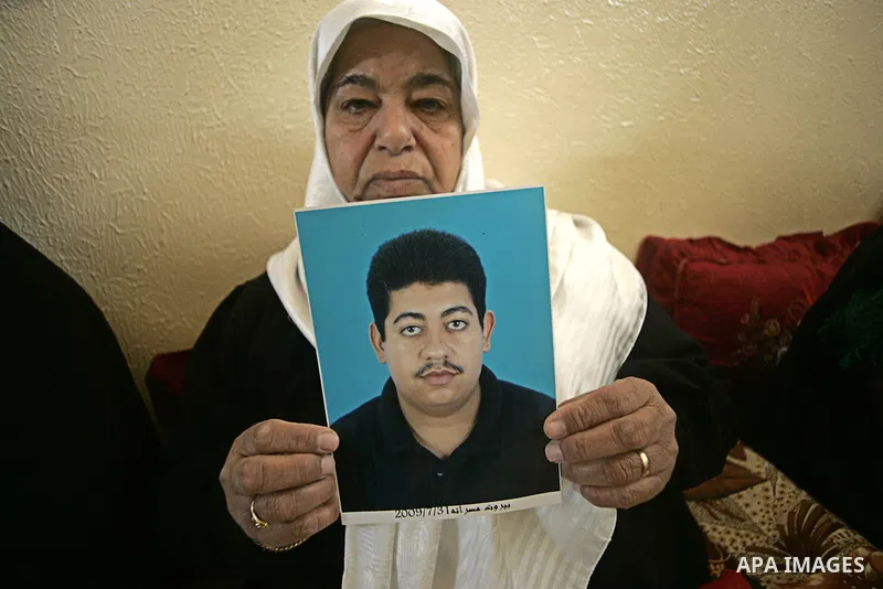 A Palestinian relative of Hasan Abu Mustafa holds his picture in his home in Khan Younis in the southern Gaza Strip on February 26, 2011. Pro-Gaddafi gunmen shot and killed Palestinian student Hasan Abu Mustafa outside h...
