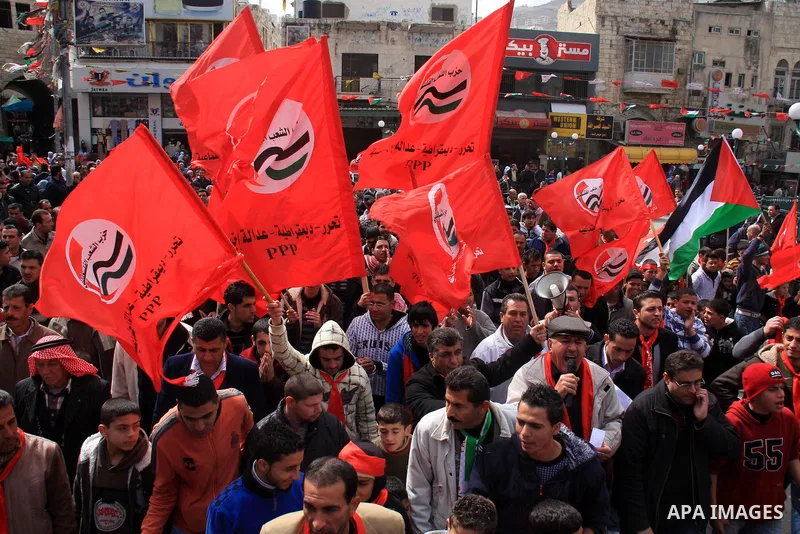 Palestinian supporters of the Palestinian Peoples Party (PPP) wave party flags as they rally in the centre of the West Bank city of Nablus demanding an end to the split between the Gaza Strip and the West Bank and callin...