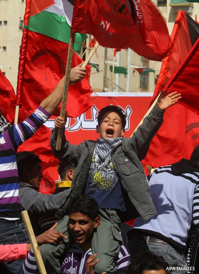 A Palestinian supporter of the Democratic Front for the Liberation of Palestine (DFLP) carries party flag during a rally celebrating 42 years since its founding in Gaza City, Saturday, Feb. 26, 2011. Founded in 1969 the...