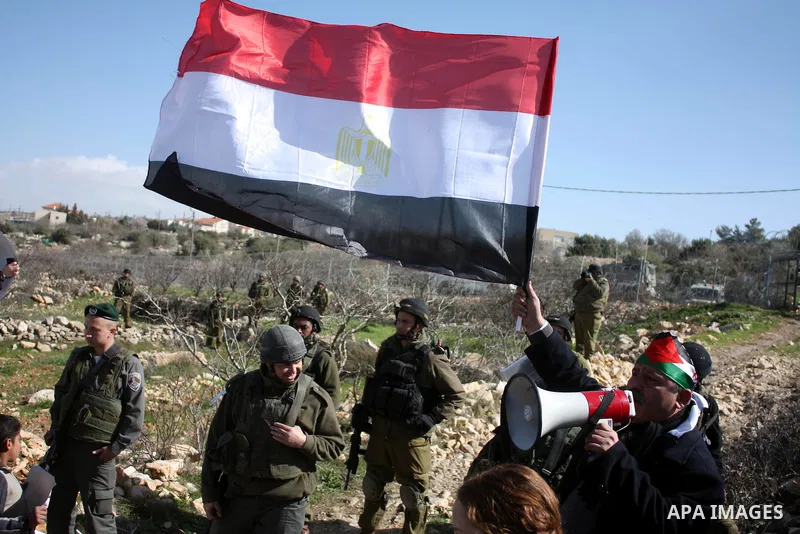 Israeli soldiers stand guard during a demonstration by Palestinian, Israeli and foreign activists against the demolishing of farm land to be used in the construction of Jewish settlements near the existing Israeli settle...