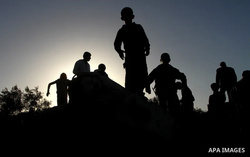 Palestinian onlookers gather at the scene of an Israeli air strike in the al-Burij refugee camp in the central Gaza Strip on February 26, 2011. Israeli warplanes bombed two training camps of the hardline Islamic Jihad gr...