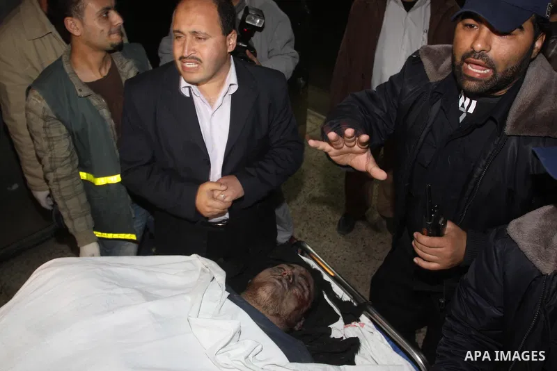 Palestinians gather around the body of a man at the mortuary of Al-Shifa hospital in Gaza City on February 27, 2011 after he was killed when an Israeli tank opened fire on a group of militants, medical sources and witnes...