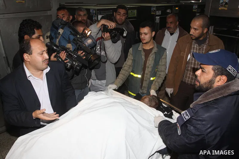Palestinians gather around the body of a man at the mortuary of Al-Shifa hospital in Gaza City on February 27, 2011 after he was killed when an Israeli tank opened fire on a group of militants, medical sources and witnes...