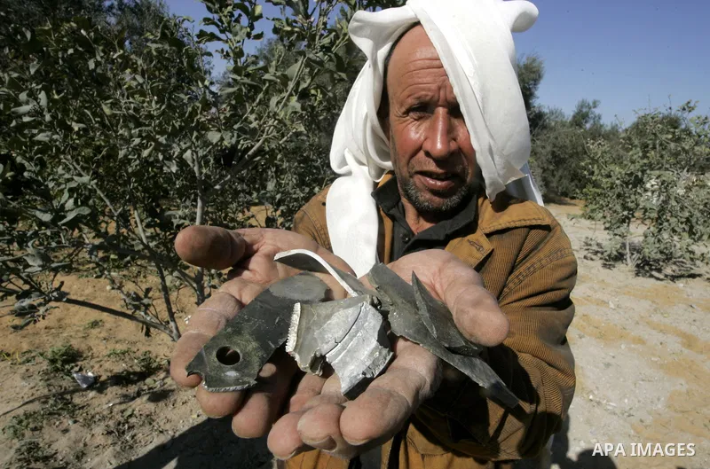 A Palestinian man carries shrapnel that hit house by Israeli artillery, in the southern Gaza strip town of Rafah on February 28, 2011. A Palestinian laborer was injured who was collecting gravel near the airport, while t...