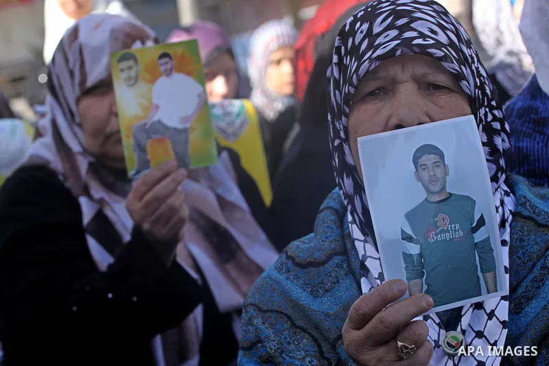 Palestinian women hold pictures of jailed relatives during a protest calling for the release of Palestinian prisoners from Israeli jails at the Red Cross office in Gaza City on Feb. 28, 2011. Photo by Mohammed Asad