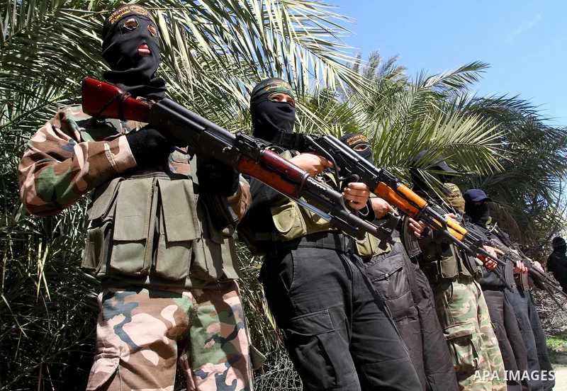 Masked Islamic Jihad militants wait next to the family house of Abeed Shaheen, killed by Israeli shell on Sunday, in Deir al-Balah refugee camp, central Gaza Strip, Monday, Feb. 28, 2011. Photo by Ashraf Amra