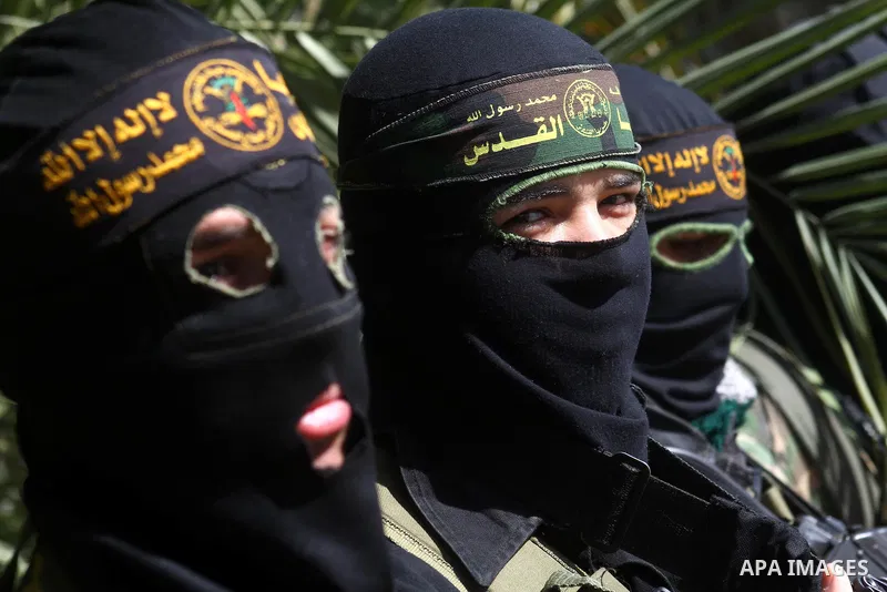 Masked Islamic Jihad militants wait next to the family house of Abeed Shaheen, killed by Israeli shell on Sunday, in Deir al-Balah refugee camp, central Gaza Strip, Monday, Feb. 28, 2011. Photo by Ashraf Amra