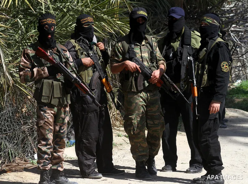 Masked Islamic Jihad militants wait next to the family house of Abeed Shaheen, killed by Israeli shell on Sunday, in Deir al-Balah refugee camp, central Gaza Strip, Monday, Feb. 28, 2011. Photo by Ashraf Amra